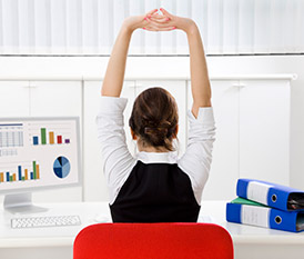 woman stretching sitting at desk